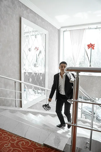 Жених с букетом поднимается по лестнице