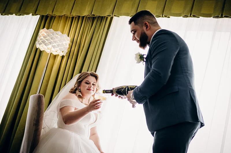 Жених наливает шампанское невесте