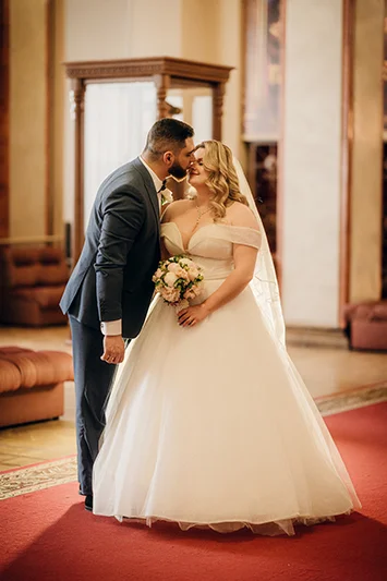 Жених целует невесту в интерьере