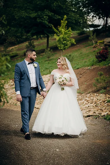 Жених и невеста прогуливаются по парку