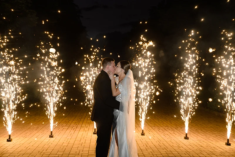 Жених и невеста целуются на фоне фейерверков